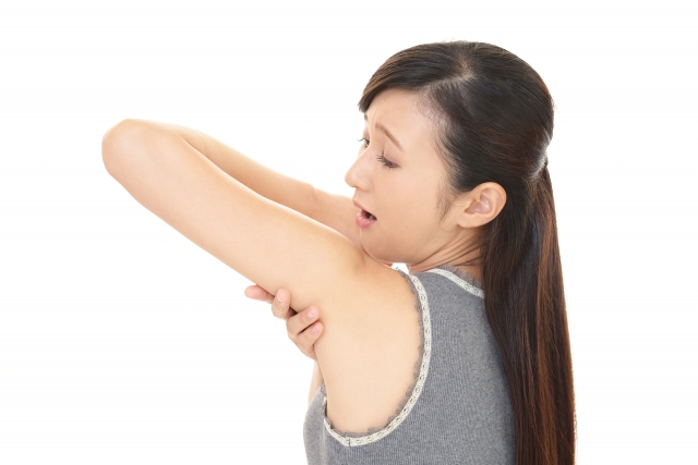 脇を気にしている女性