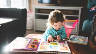 小さい子供が絵本を読んでいる画像