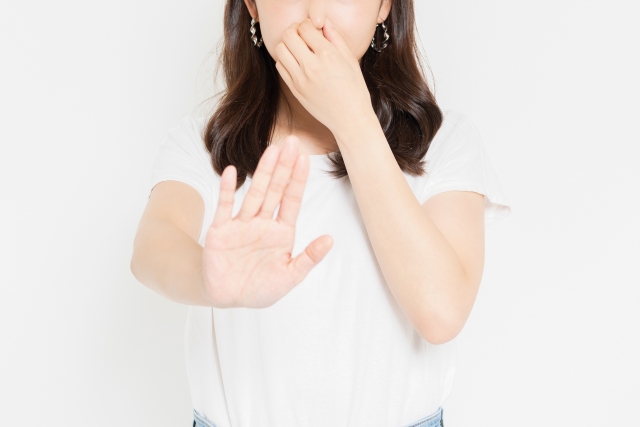 臭くて鼻をつまむ女性