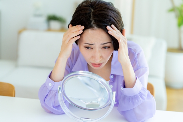 髪の毛を気にする女性
